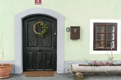 a black door with a wreath next to a window at Hiša Borov Gaj in Mojstrana