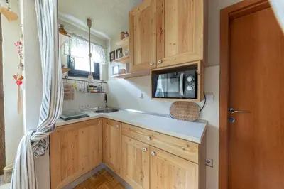 a kitchen with wooden cabinets and a sink and a microwave at Apartma Brlog Petra, Kranjska Gora in Kranjska Gora