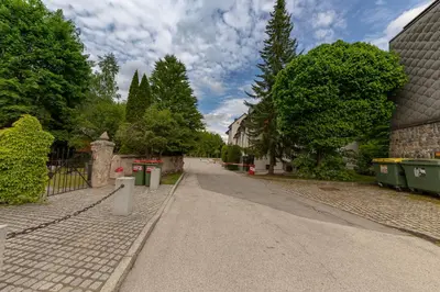 an empty street with trees and a fence at Apartma Brlog Petra, Kranjska Gora in Kranjska Gora