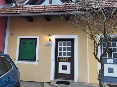 a house with a green door and a car parked outside at Appartement Camp Terme Čatež P93 in Čatež ob Savi
