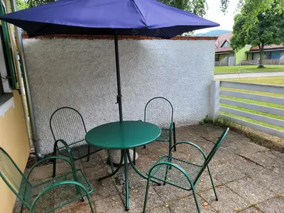 a table and chairs with an umbrella on a patio at Appartement Camp Terme Čatež P93 in Čatež ob Savi