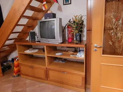 a television on a wooden shelf with a ladder at Appartement Camp Terme Čatež P93 in Čatež ob Savi