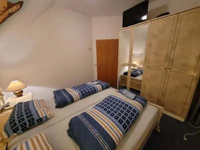 a bedroom with two beds and a cabinet at Appartement Camp Terme Čatež P93 in Čatež ob Savi