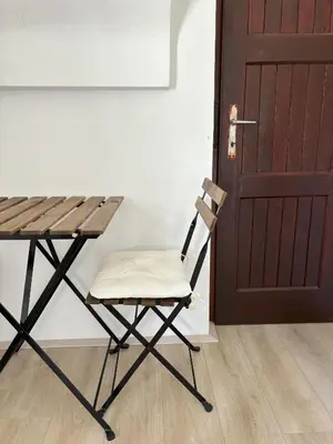 a chair next to a table and a door at Apartments Heart in Ljubljana
