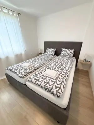 a bedroom with a large bed with a black and white comforter at Apartments Heart in Ljubljana