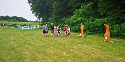 a group of people standing in a field with statues at Camping Silva in Ljutomer
