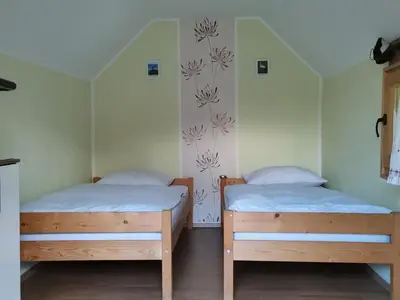 two twin beds in a room with a wall at Camping Silva in Ljutomer