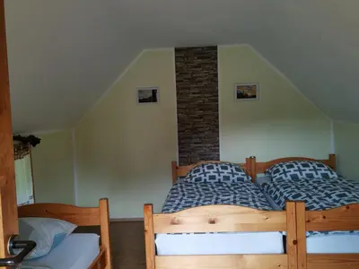 two twin beds in a room with a brick wall at Camping Silva in Ljutomer