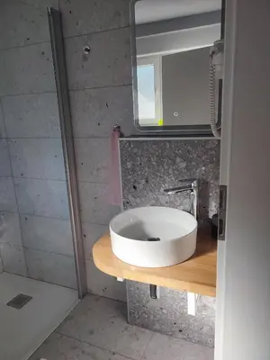 a bathroom with a white sink and a mirror at Tilka`s house in Blejska Dobrava