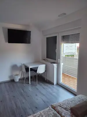 a white room with a table and chairs and a window at Tilka`s house in Blejska Dobrava