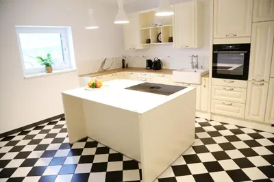 a white kitchen with a black and white checkered floor at Maribor Luxury Country House Volicina 5* in Spodnja Voličina