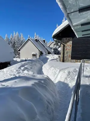 a yard covered in snow next to a house at Apartma Tisa in Zreče