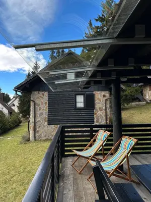 two chairs sitting on the deck of a house at Apartma Tisa in Zreče