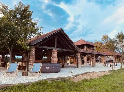 a pavilion with two lounge chairs in front of it at Villa Goričko in Šalovci