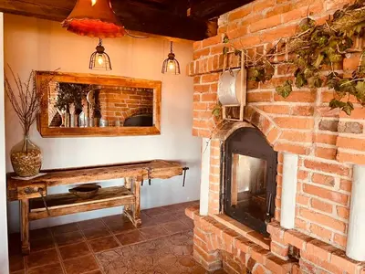 a living room with a brick fireplace and a table at Villa Goričko in Šalovci