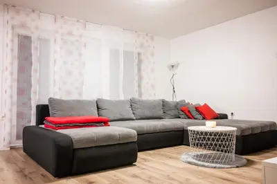 a living room with a gray couch and red pillows at Apartma Tia 2 in Zreče