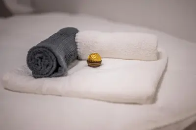 a white bed with towels and a gold object on it at Apartma Tia 2 in Zreče