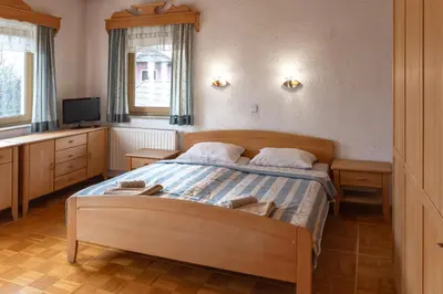 a bedroom with a bed and a television in it at Gostišče Marin Miler in Prevalje