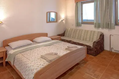 a small bedroom with a bed and a couch at Gostišče Marin Miler in Prevalje