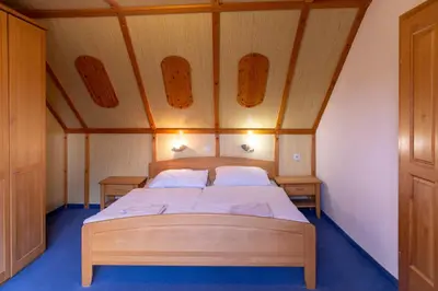 a bedroom with a wooden bed in a room at Gostišče Marin Miler in Prevalje