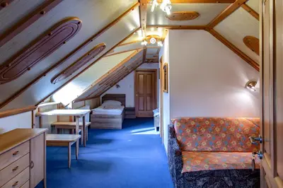 a room with a couch and a table in a train at Gostišče Marin Miler in Prevalje