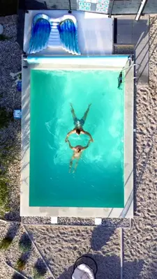 a person swimming in the water in a pool at Holiday House Sunset Spa in Šentjernej