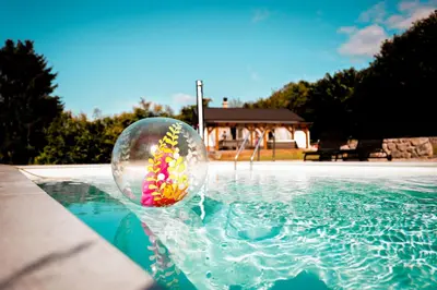 a glass ball filled with sprinkles in a swimming pool at Holiday House Sunset Spa in Šentjernej