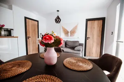 a dining room table with a vase with flowers on it at Holiday House Sunset Spa in Šentjernej