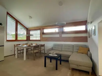 a living room with a couch and a table at Klinar - Attractive new two-story apartment in Bled