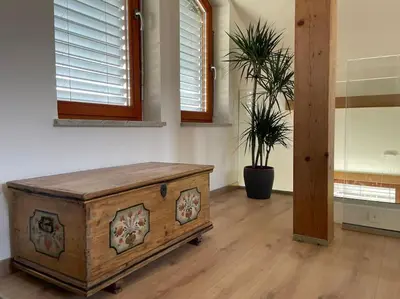 a room with a wooden chest and two windows at Klinar - Attractive new two-story apartment in Bled
