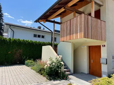 a house with a wooden door in a yard at Klinar - Attractive new two-story apartment in Bled
