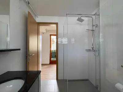 a bathroom with a glass shower and a sink at Klinar - Attractive new two-story apartment in Bled