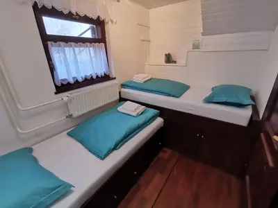 two beds in a small room with a window at Cosy Forest in Kranjska Gora