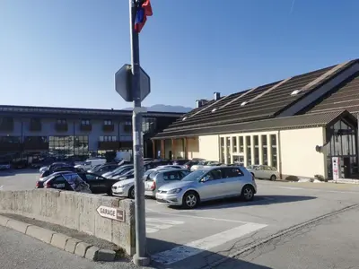 a parking lot with cars parked in front of a building at Cosy Forest in Kranjska Gora