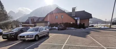 a parking lot with cars parked in front of a house at Cosy Forest in Kranjska Gora