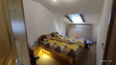 a bedroom with a bed with a yellow and blue comforter at Prijetno stanovanje v bližini Term 3000 - Vivat in Moravske Toplice