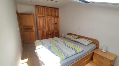 a bedroom with a bed and a wooden cabinet at Prijetno stanovanje v bližini Term 3000 - Vivat in Moravske Toplice