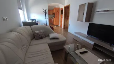 a living room with a white couch and a flat screen tv at Prijetno stanovanje v bližini Term 3000 - Vivat in Moravske Toplice