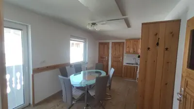a kitchen with a table and chairs in a room at Prijetno stanovanje v bližini Term 3000 - Vivat in Moravske Toplice