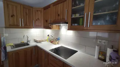 a kitchen with wooden cabinets and a sink at Prijetno stanovanje v bližini Term 3000 - Vivat in Moravske Toplice