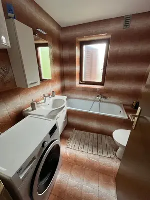 a bathroom with a sink and a washing machine at Apartma Zdar in Kobarid