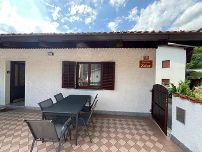 a patio with a table and chairs in front of a house at Apartma Zdar in Kobarid