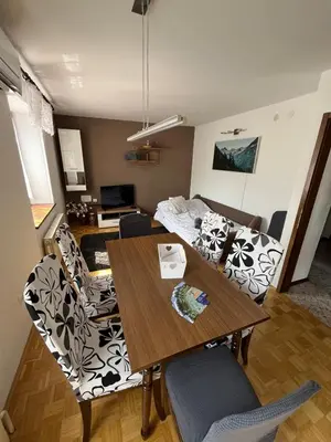a living room with a dining table and a couch at Apartma Zdar in Kobarid