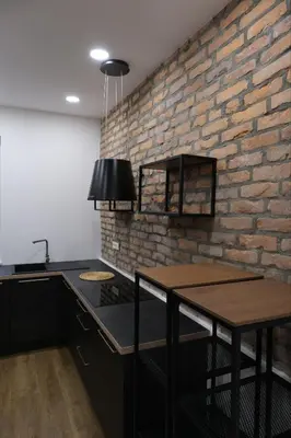 a kitchen with a brick wall and a table at Apartments Emona FREE Parking & gym in Ljubljana