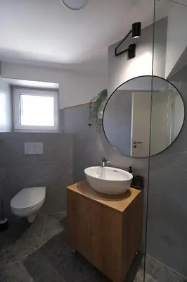 a bathroom with a sink and a toilet and a mirror at Apartments Emona FREE Parking & gym in Ljubljana