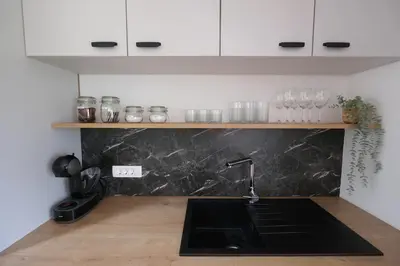 a kitchen with a sink and a counter top at Apartments Emona FREE Parking & gym in Ljubljana