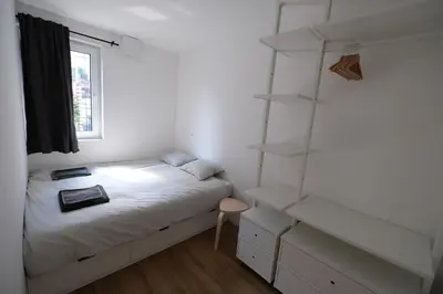a bedroom with a bed with white sheets and shelves at Apartments Emona FREE Parking & gym in Ljubljana