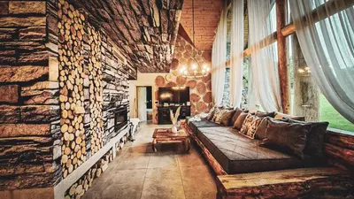 a living room with a couch and a stone wall at Koča na samem Prestiž in Šalovci