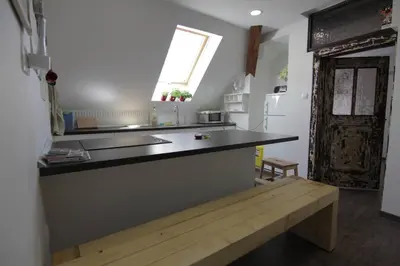 a kitchen with a counter with a bench in front of it at Entire apartment in the center with free parking in Ljubljana