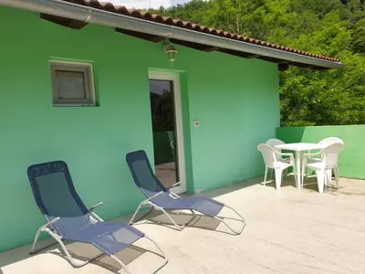 a patio with chairs and a table in front of a building at Apartma Patricija - Cozy apartments for 2 or 4 people in Tolmin